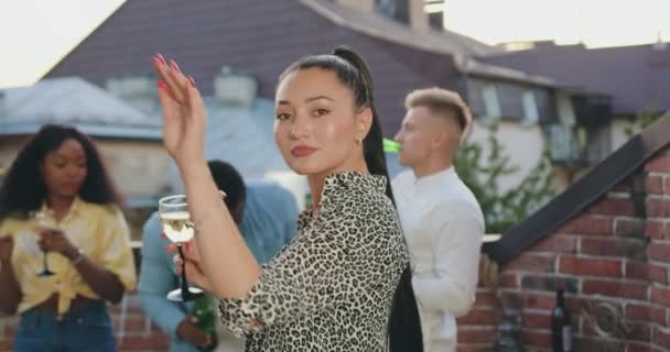 Close up of pretty satisfied carefree young asian woman which dancing on the camera near her joyful multiracial friends during summer party — Stock Video