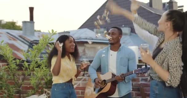 Primer plano de buen aspecto sonriente feliz despreocupado diversos jóvenes que se divierten juntos en la terraza mientras celebran fiesta de amigos — Vídeo de stock