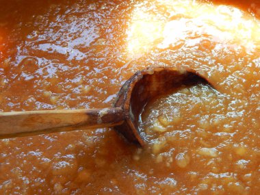 elma reçeli bir kapta demlenir ve tahta bir kaşıkla karıştırılır.