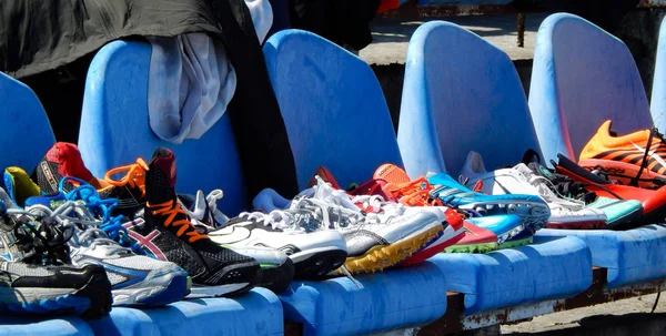 Tênis esportivos empilhados nas cadeiras do estádio — Fotografia de Stock