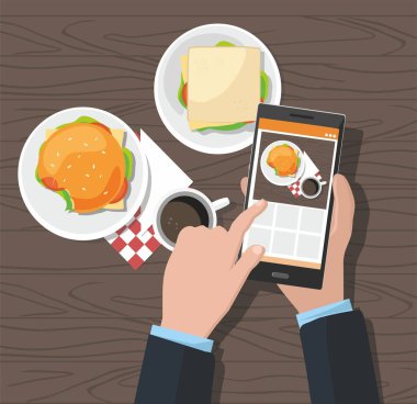 Mobil fotoğraf kavramı. Adam akıllı telefon üzerinde fotoğraf hamburger ve kahve alarak 