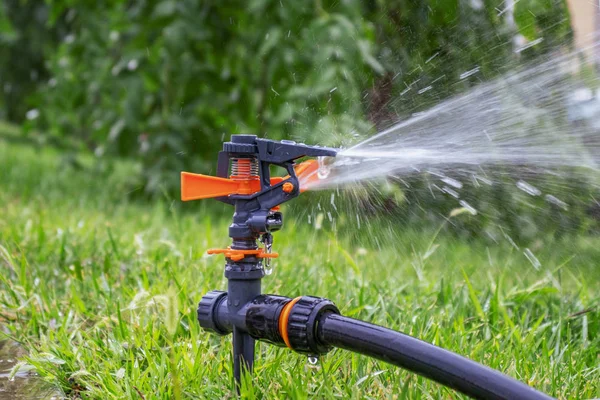 Sprinkler. Automatic irrigation system on the background of green grass. Lawn watering system. Freshness concept