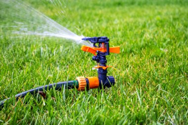 Yağmurlama. Yeşil çim arka planda otomatik sulama sistemi. Çim sulama sistemi. Tazelik konsepti