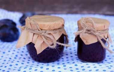 Kavanoz ve masanın üzerine taze erik erik reçeli. Seçici odak. Eve yapılan, bulanık.
