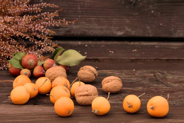 Autumn styled botanical arrangement. Composition of little apples and little pears,walnuts and erica on wooden table background. Fall decorative concept. — Stock Photo, Image