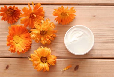 Merhem kadife çiçeği, taze calendula çiçekler. Bitkisel Kozmetik ürünleri. Ahşap arka plan, üstten görünüm.