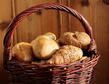 Taze ekmek sepeti ahşap arka planda natürmort üzerinde karıştırın. Yan görünüm, gıda, sizin metin için yer kavramı.