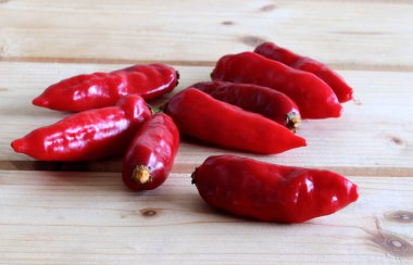 Olgunlaşmış Bhut jolokia kırmızı, çok sıcak biber ahşap masa üzerinde gıdalar arka plan için resim tasarım grubu.