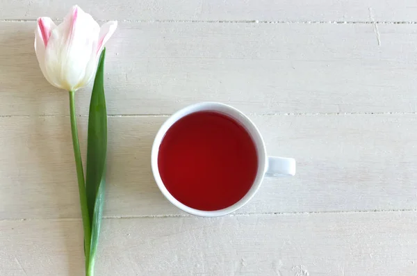 Fondo romántico con taza de té y tulipanes sobre mesa blanca. Una foto suave. Estilo tarjeta de felicitación, lugar para el texto. Vista superior. Composición San Valentín . —  Fotos de Stock