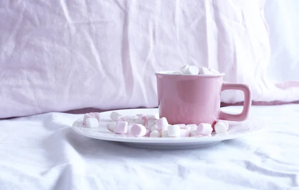 Warme cacao met marshmallow in een roze keramische mok op een bed. Het begrip vakantie en nieuwjaar. roze linnen achtergrond. Vlakke lay, bovenaanzicht. — Stockfoto