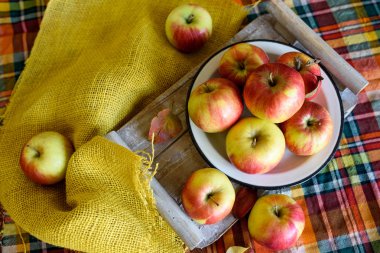 Bir tabloda bir plaka üzerinde kırmızı sarı elmalar