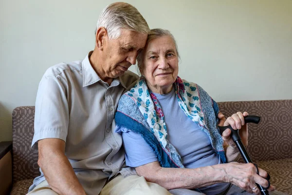 Family, elderly couple. The old man hugs his wife. Spouses who have lived together for more than 50 years. Concept: Happy old age, care, love.