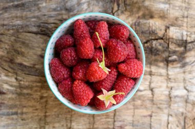 Ahşap arka plan üzerinde kase taze ahududu