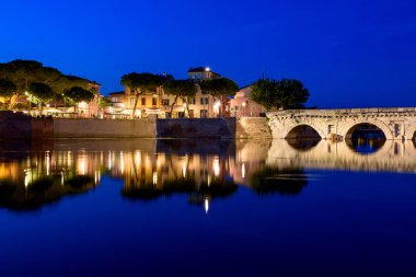 Tiberius köprü gece. Rimini, İtalya. Suya yansıyan şehir ışıkları.