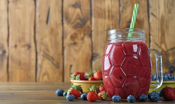 Berry smoothies ahşap arka plan üzerinde