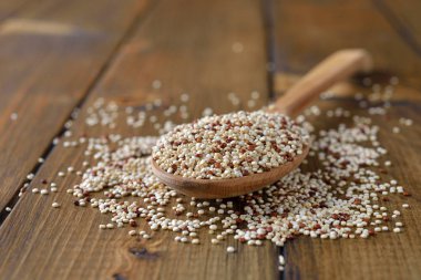 Kahverengi bir arka plan üzerine bir tahta kaşık Quinoa