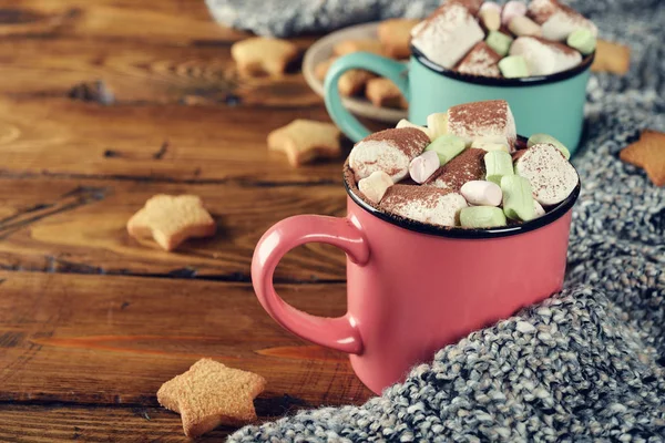 Cup of cocoa decorated with marshmallow on a wooden background
