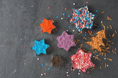 Gri bir arka plan üzerinde yıldızların çok renkli badem