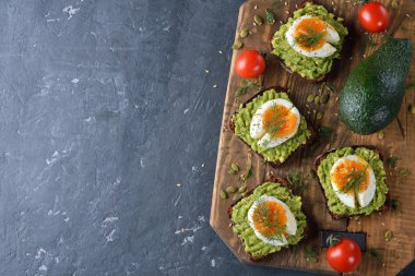 Yumurta ve gri arka plan üzerinde avokado vejetaryen tost