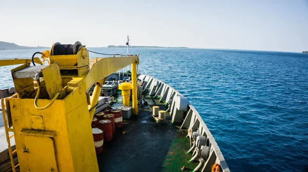 a ship from front deck view load a petrol oil barrel in Indonesia deep blue sea in karimun jawa sea