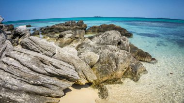 Mavi Turkuaz ile sahilde taş mercan su deniz ve kum karimun jawa Endonezya