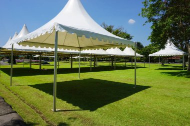 Yeşil çimenlerin üzerinde döken - fotoğraf Endonezya ile Bahçe park ile beyaz çadır