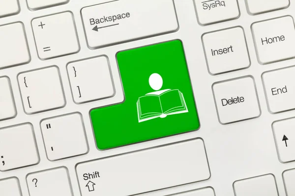 Bílá koncepční klávesnice - zelený klíč symbolem člověka a kniha — Stock fotografie