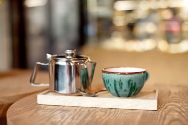 Natürmort fincan çay, Çaydanlık ve tepsi ile kafeterya iç ahşap bir masa ayarlamak 