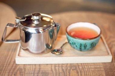 Natürmort fincan çay, Çaydanlık ve tepsi ile kafeterya iç ahşap bir masa ayarlamak 