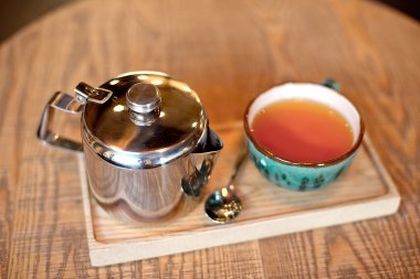 Natürmort fincan çay, Çaydanlık ve tepsi ile kafeterya iç ahşap bir masa ayarlamak 