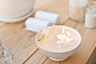Spa aroma banyo mum ile ayarla ve havlu üzerinde ahşap masa haddelenmiş