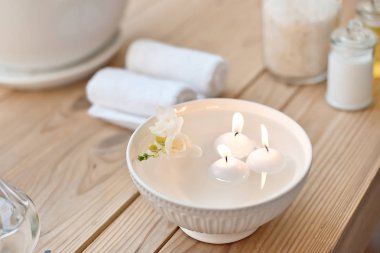 Spa aroma banyo mum ile ayarla ve havlu üzerinde ahşap masa haddelenmiş