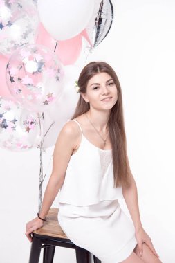 Beyaz arka plan üzerinde izole balonlarla eğleniyor gülümseyen güzel kadın