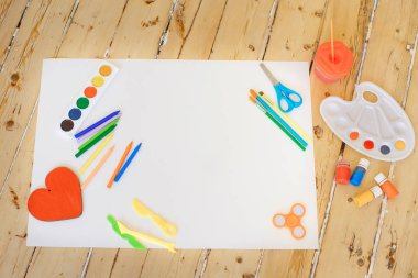 Boyalar ve kalemler ve düz beyaz tuval ahşap arka plan üzerinde fırça set