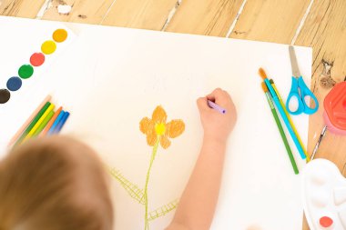 Küçük sarışın kız boyama çiçek beyaz kağıt üzerinde 