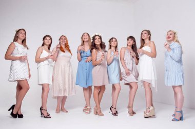 Eğleniyor ve bardak şampanya beyaz stüdyo arka plan üzerinde ile kızartma mutlu kızlar 