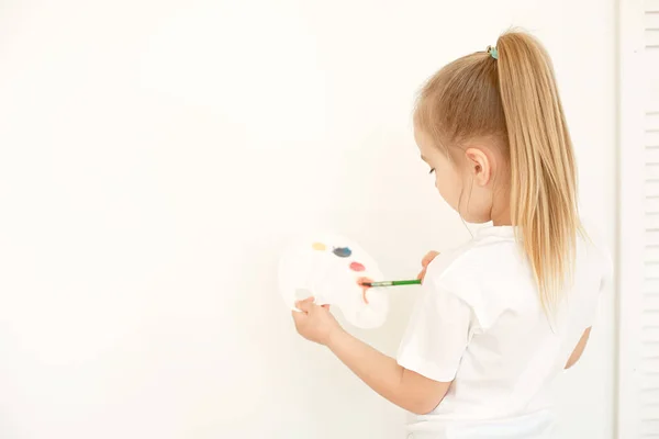 Bonito menina pintura no parede no vazio quarto — Fotografia de Stock