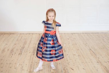 Çevresinde kapalı yeni elbise hayran iken iplik renkli elbiseli çekici küçük kız