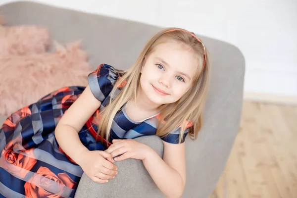 Attraktives Kleines Mädchen Buntem Kleid Sitzt Auf Grauem Sofa Haus — Stockfoto
