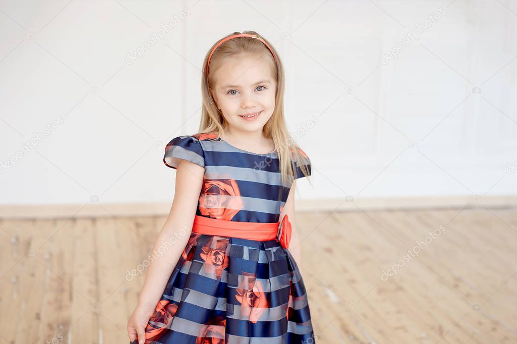 Attractive girl in colorful dress smiling  looking at camera indoor