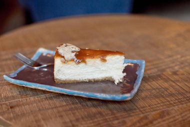 plaka üzerinde ahşap masa, lezzetli kremalı pastadan dilim ile yakın çekim