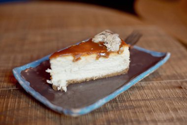 plaka üzerinde ahşap masa, lezzetli kremalı pastadan dilim ile yakın çekim