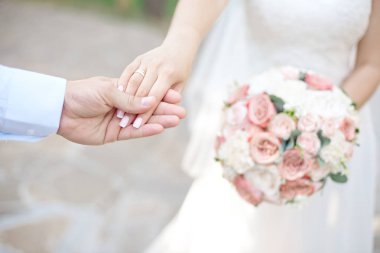 Yakın çekim gelin ve damadın elleri ile Nikah yüzükleri. Koyarak altın yüzük parmağına damat. Aşk ve evlilik.
