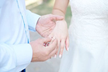 Yakın çekim gelin ve damadın elleri ile Nikah yüzükleri. Koyarak altın yüzük parmağına damat. Aşk ve evlilik.