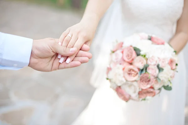 Yakın çekim gelin ve damadın elleri ile Nikah yüzükleri. Koyarak altın yüzük parmağına damat. Aşk ve evlilik.