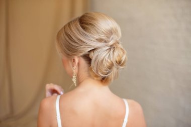 Sarı saçlı kadın saç modeli orta topuz arka görünümü.