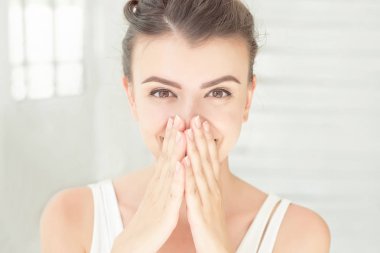 Kahverengi gözlü beyaz parlak oda kapalı yanaklara elele mutlu kadın portre yakın çekim şaşırttı