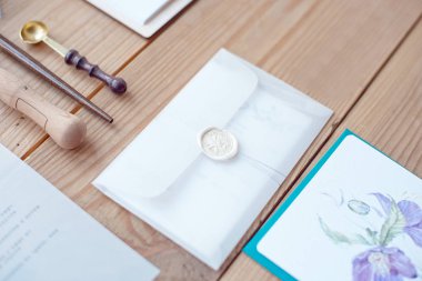 Natürmort düğün davetiye zarfları ve dantel kartları hat aletleri ve dekor ahşap zemin üzerinde