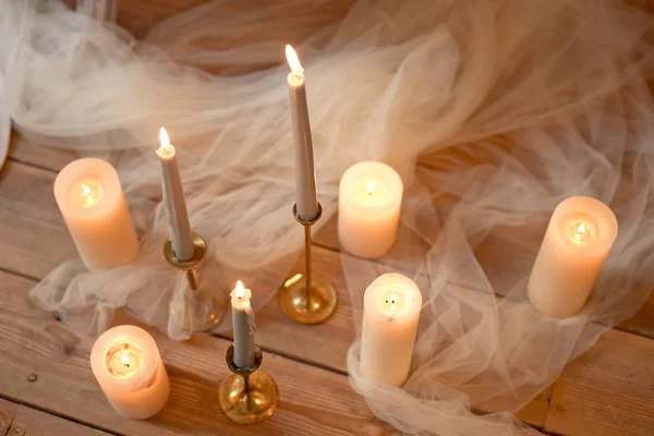在高角度的角度视图中 木地板上的白色薄纱 烛台和燃烧的蜡烛 — 图库照片