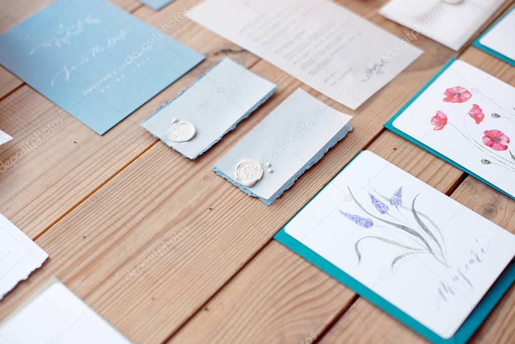 Still life of wedding invitation envelopes and lace cards with decor on wooden floor